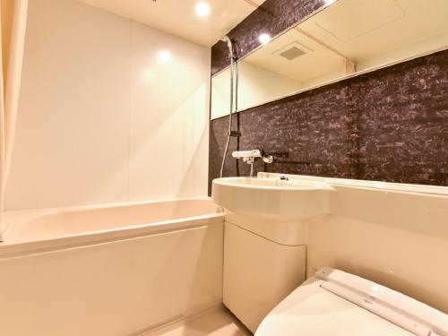 福岡市にあるホテルリブマックス 博多中洲の白いバスルーム(洗面台、トイレ付)
