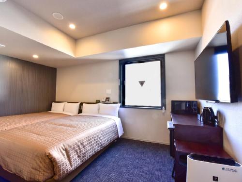 una stanza d'albergo con un letto e una finestra di HOTEL LiVEMAX Hakata Nakasu a Fukuoka