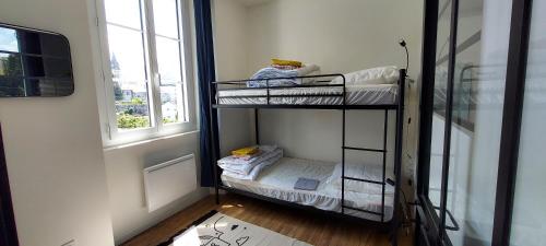 2 beliches num quarto com uma janela em Escapade à Lourdes dans T2 Bis proche Gare et Centre ville em Lourdes