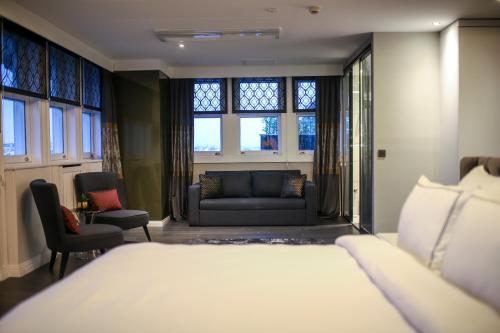 a bedroom with a bed and a couch and windows at Loop Hotel Bosphorus İstanbul in Istanbul