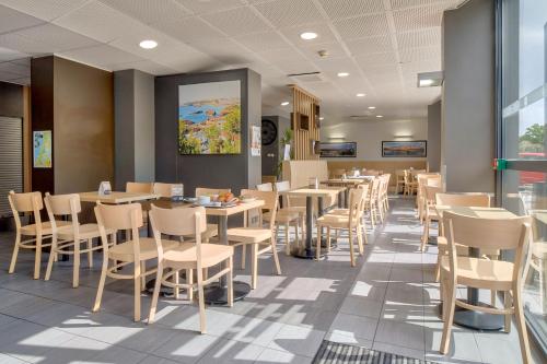 une salle à manger avec tables et chaises dans l'établissement B&B HOTEL Bayonne Tarnos, à Tarnos