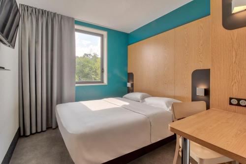 Una habitación de hotel con una cama y una ventana. en B&B HOTEL Bayonne Tarnos, en Tarnos