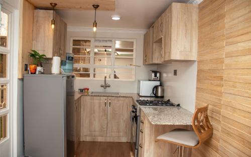 a kitchen with wooden cabinets and a refrigerator at Redhill Container House & Private Spa in Nairobi