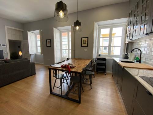 eine Küche und ein Wohnzimmer mit einem großen Holztisch in der Unterkunft Casa da Serpa Pinto in Évora
