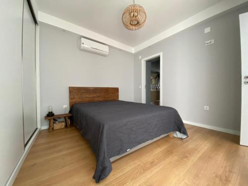 um quarto com uma cama e piso em madeira em Casa da Serpa Pinto em Évora
