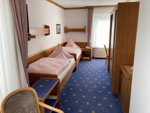 a room with two beds and a table and a desk at Bengel's Hotel zur Krone in Mülheim-Kärlich