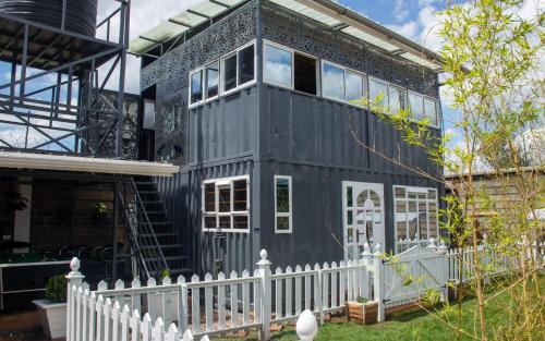a black house with a white fence at Redhill Container House & Private Spa, Ndenderu, btn Nairobi Ruaka Area, Tigoni, Limuru in Kiambu County, Apartments O7II, 585, OOO in Nairobi