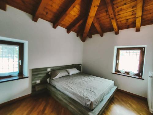 a bedroom with a bed and two windows at Mela e Pera in Treviglio