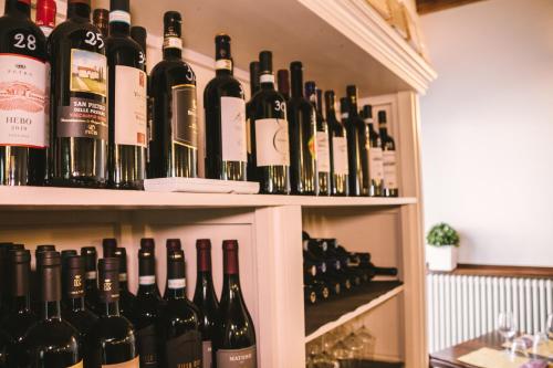 a bunch of bottles of wine sitting on a shelf at Mela e Pera in Treviglio