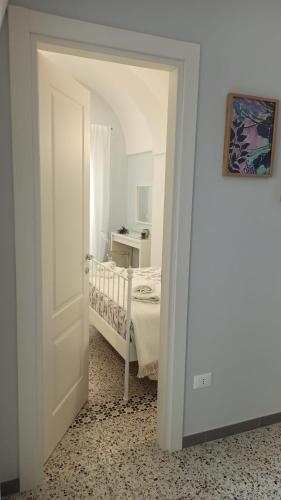 a white room with a bed and a white door at B&B Puglia d'aMare in Lizzano