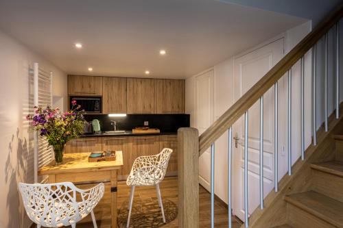 une cuisine avec une table et des chaises ainsi qu'un escalier dans l'établissement Chez Mimi - La Petite Tour, à Raulhac