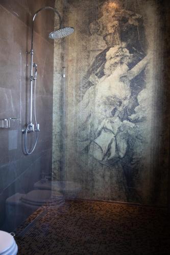 a bathroom with a shower with a painting on the wall at Hotel Villa Pascucci in Durrës