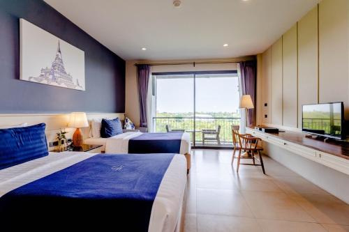 a hotel room with two beds and a large window at The Cavalli Casa Resort in Phra Nakhon Si Ayutthaya