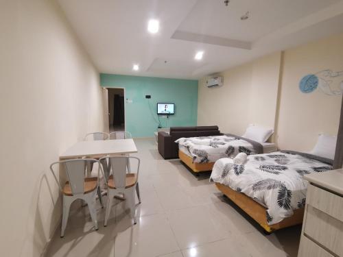 ein Wohnzimmer mit 2 Betten und einem Sofa in der Unterkunft Rustic one bedroom unit for 4 pax with Sea View by JoMy Homestay in Lumut