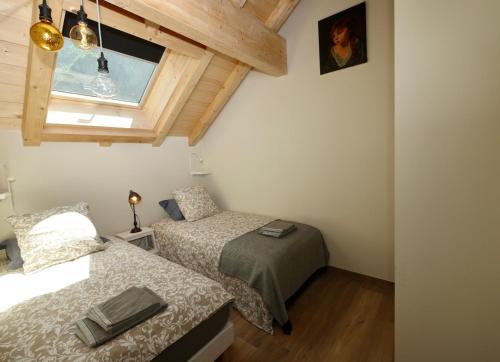 1 dormitorio con 2 camas y ventana en Au Vert !, en Le Vert