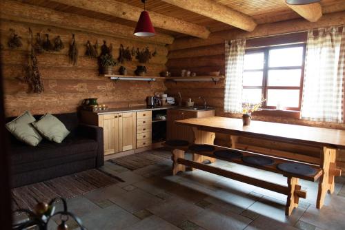 a kitchen with a table and a couch in a room at Piešupīte in Staburags