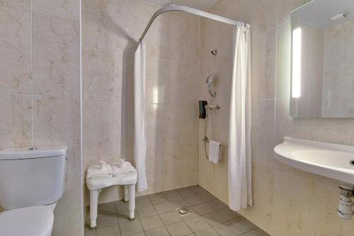 Un baño con inodoro, lavabo y ducha. en B&B HOTEL Bayonne Tarnos, en Tarnos