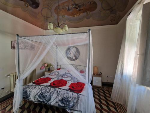 a bedroom with a bed with red roses on it at PalazzoRegina in Pergola