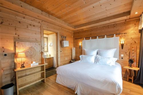 a bedroom with a white bed in a wooden room at Chalet-Hôtel Hermitage in Chamonix-Mont-Blanc