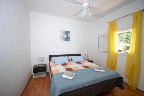 a bedroom with a bed with two towels on it at Holiday House Roza in Vela Luka