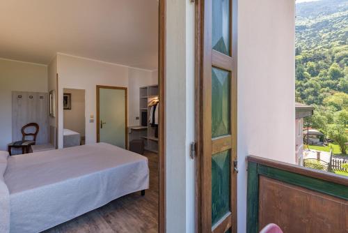 a bedroom with a bed and a window with a view at Hotel Aurora in Cimego