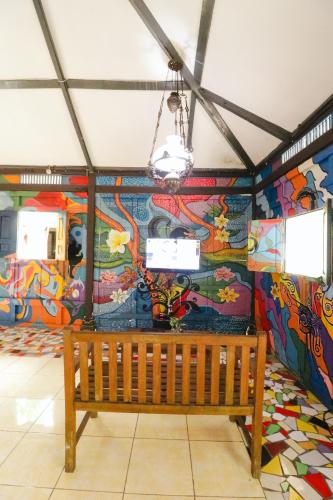 a bench in a room with a colorful wall at Kampoeng Semar Borobudur in Magelang