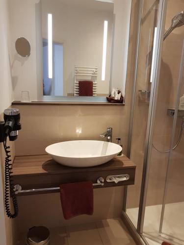 a bathroom with a sink and a shower at Ringhotel Villa Margarete in Waren