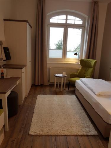 a bedroom with a bed and a window and a rug at Ringhotel Villa Margarete in Waren