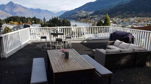 a balcony with a couch and a table and chairs at With amazing rooftop-Central Lakeview 3bedrooms Apartments镇上湖景三室套房 in Queenstown