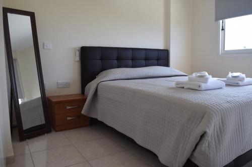 a bedroom with a large bed with towels on it at Eden Heights Sea View Apartment 203 - By IMH Travel & Tours in Paphos City