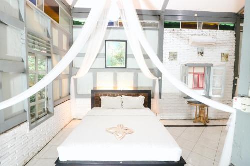 a bedroom with a bed in a room with windows at Kampoeng Semar Borobudur in Magelang