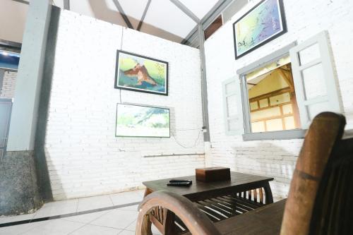 a room with a bench and a window and a table at Kampoeng Semar Borobudur in Magelang