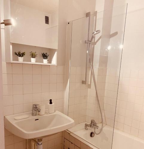 une salle de bain blanche avec un lavabo et une douche dans l'établissement KASA VOYTIER Parking privé & Wifi - Balcon & Ascenseur, à Saint Etienne