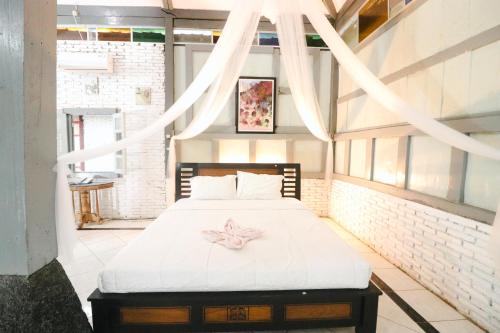 a bedroom with a bed with a pink flower on it at Kampoeng Semar Borobudur in Magelang