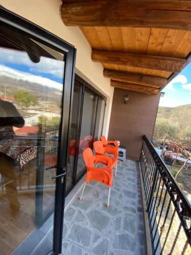 una fila de sillas naranjas en el balcón de una casa en Villa Shuaipaj, en Gjirokastra