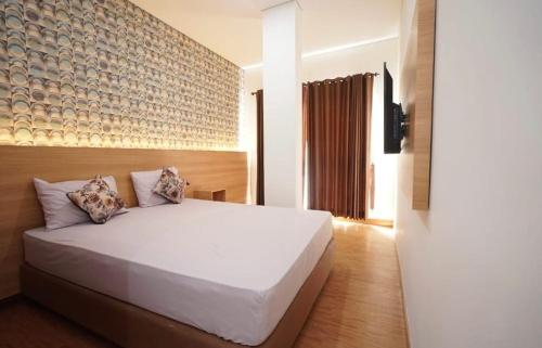 una camera con un grande letto bianco di SENAYAN SUITES a Giacarta