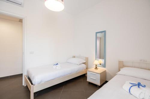 a bedroom with two beds and a mirror at GuestHost - Salento Sole e Mare Luxury with Pool in Lendinuso