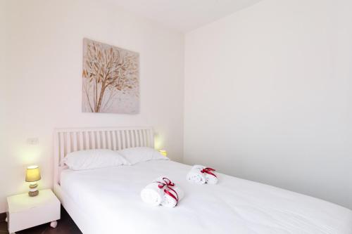 a white bed with two hello kitty towels on it at GuestHost - Salento Sole e Mare Luxury with Pool in Lendinuso