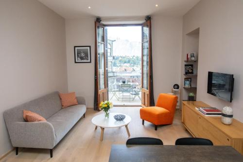 ein Wohnzimmer mit einem Sofa und einem Tisch in der Unterkunft Villa Saint Enogat in Aix-les-Bains