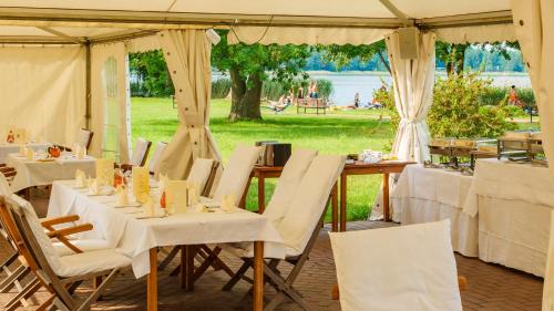 a marquee with white tables and chairs in a field at Seepark Hotel am Wandlitzsee in Wandlitz
