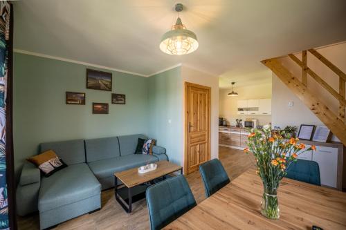 a living room with a couch and a table at Centrum Spokoju - Domki w Karkonoszach in Podgórzyn