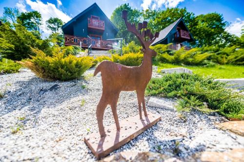 a wooden statue of a deer standing on a stand at Centrum Spokoju - Domki w Karkonoszach in Podgórzyn
