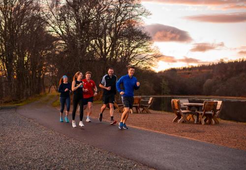 a group of people walking down a path near a lake at Balnagown Estates in Kildary