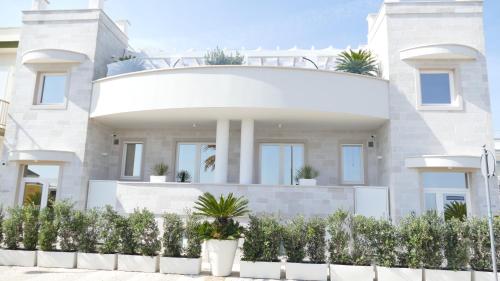 a white house with plants in front of it at La Caletta Suite Torre Canne in Torre Canne