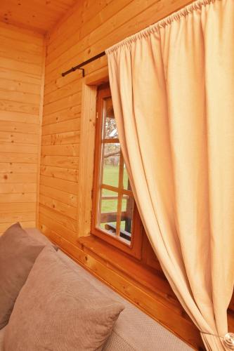 a bedroom with a window in a log cabin at Gospodarstwo Agroturystyczne z BASENEM & SPA i Alpakami in Ełk