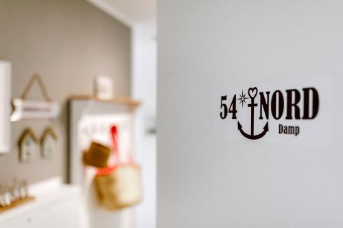 a kitchen with a white refrigerator with a sign on it at 54' Nord Damp in Damp