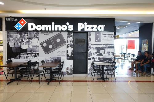 a dominos pizza restaurant with tables and chairs at ITCC Manhattan Suites by Calvin in Donggongon