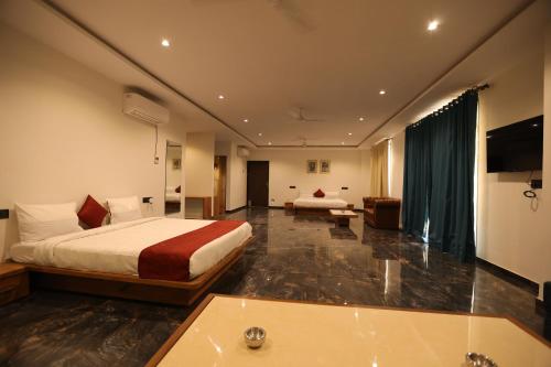 um quarto de hotel com uma cama e uma banheira em The Heritage Conventions em Sāgar