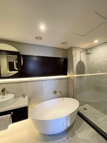 a bathroom with a large tub and a sink at Premier Hotel Cape Town in Cape Town