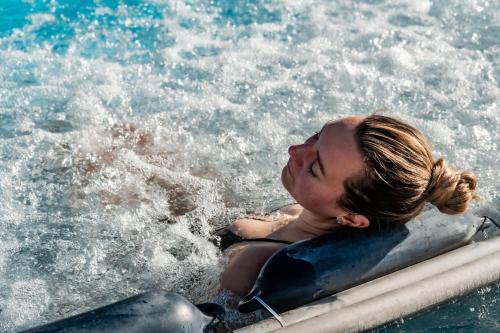 a woman laying on a raft in the water at De France by Thermalhotels in Leukerbad